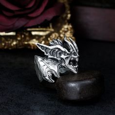 ✪Product details: ◆Material: 925 silver\brass ◆Size: about 27mm*27mm ◆Weight: about 27 grams (silver)\about 22 grams (brass) ◆Note: Since the jewelry is handmade, sizes will vary slightly. ◆Please Note: Weight and size will vary based on each person's desired size. ◆About the details: This is a handmade gothic gargoyle ring with a full retro feel. The details are perfect, the owner has a thick texture, the workmanship is antique, and the craftsmanship requirements are very high. Shown in my original antique finish, but also available in all black or polished finishes. If you would like this ring in a different finish or ring size, please message me.  In this world, you will not find another exactly the same. You can even ask us to engrave the text you want on the logo. This is your unique Gargoyle Ring, Luxury Handmade Gothic Skull Ring, Luxury Silver Gothic Skull Ring, Silver Gothic Skull Ring, Silver Gothic Skull Ring Collectible, Gothic Gargoyles, Unique Silver Jewelry, Bat Wings, Rings Statement