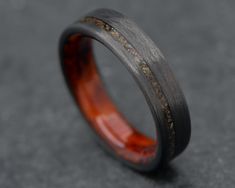 "Elevate your style with our 5mm handcrafted ring the Vertex. Meticulously crafted to perfection, this unique ring features a durable CarbonUni core, ensuring its longevity. Finishing things off are a captivating T-Rex bone inlay and Amboyna wood inner sleeve which adds a touch of timeless elegance.  ✯ This ring is made with the following options: ◎ Core ⤚ ⟶ CarbonUni ║ Inlay ⤚ ⟶ T-Rex ⟷ Width ⤚ ⟶ 5mm ❍ Inner Sleeve: ⤚ ⟶ Amboyna Wood ⋒ Profile ⤚ ⟶ Flat ≣ Finish ⤚ ⟶ Polished ▃ Thickness ⤚ ⟶ Standard ⊙ Fit ⤚ ⟶ Comfort 💧Waterproof. Each and every ring that contains delicate materials such as wood, deer antler, dinosaur bone and minerals is protected with a resin coating that is both waterproof and chemical resistant. This allows you to wear your ring 24/7 with complete peace of mind. ✒️ Pers Carbon Fiber Ring, Carbon Fiber Rings, Dinosaur Bones, Bone Inlay, Resin Coating, Handcrafted Rings, Rochester Ny, Wood Rings, Unique Ring