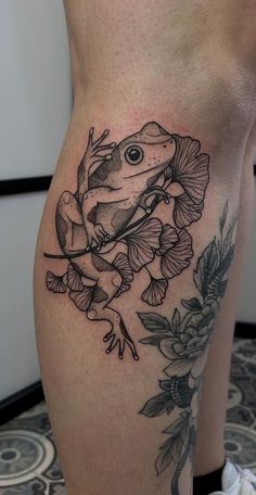 a frog sitting on top of a plant with flowers around it's legs and eyes