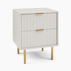 a white cabinet with two drawers and gold handles on the bottom, against a white background