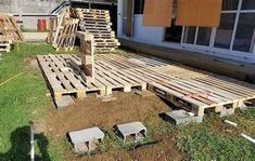 several wooden benches sitting on top of a grass covered field next to a white building