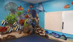 an underwater themed children's playroom with fish and corals on the wall