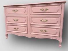 a pink dresser with gold handles and drawers