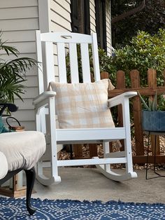 a white rocking chair sitting on top of a blue rug