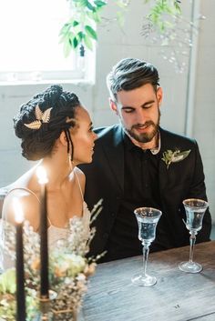 a man and woman sitting at a table with wine glasses