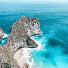 an aerial view of the ocean with two large rocks sticking out of it's sides