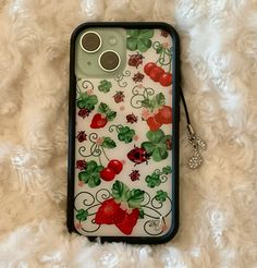 a cell phone case with strawberrys and ladybugs on white furnishing