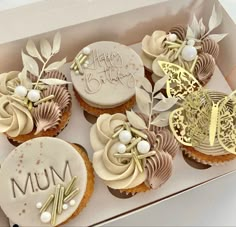 a box filled with cupcakes covered in frosting and decorated with leaves on top