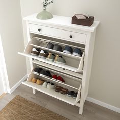 a white shoe rack with several pairs of shoes