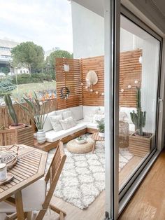 an outdoor living room with wooden slats and white furniture