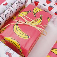 wrapping paper wrapped in red and yellow with bananas on them, tied to twine