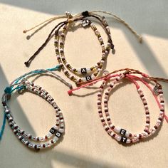 three bracelets with letters on them sitting next to each other