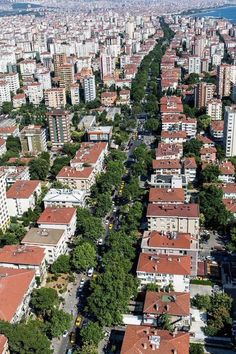 an aerial view of a city with lots of buildings and trees in the foreground