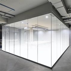 an empty room with glass partitions in the center and lights on either side of the wall