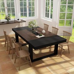 a table and chairs in a room with large windows