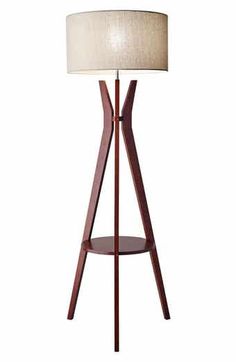 a wooden floor lamp with a white shade on the top and bottom part of it