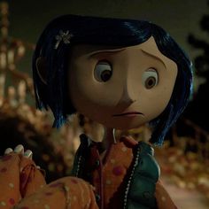 an animated doll with blue hair and polka dots on it's shirt, sitting in front of a tree