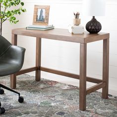 a desk with a lamp, chair and pictures on the wall