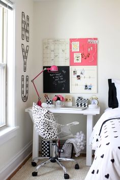 a bedroom with a desk, chair and pictures on the wall above it is decorated in black and white