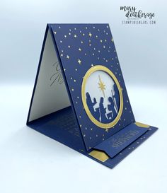 a blue card with gold trimming and a nativity scene on the inside of it