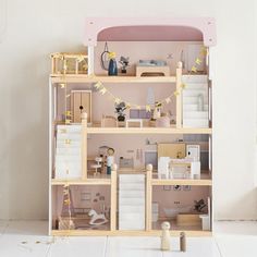 a doll house with all the furniture and accessories arranged on top of each other in front of a white wall