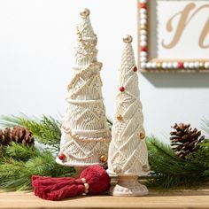 two white christmas trees sitting on top of a wooden table