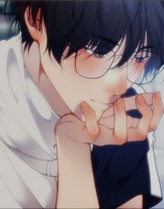 a man with black hair and glasses holding his hand to his face