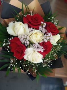 a bouquet of red and white roses