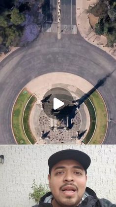 an aerial view of a man standing in front of a building and looking at the camera