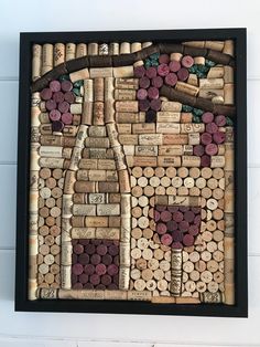 a wine bottle made out of wine corks on a white wall with black frame