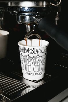 a coffee cup sitting on top of an espresso machine being filled with liquid