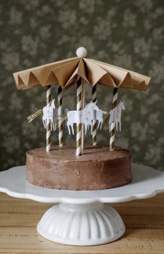 a chocolate cake topped with white candles and an umbrella