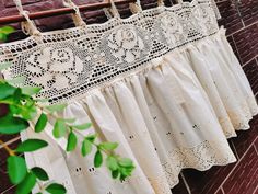 white crochet curtains hanging on a brick wall