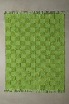 a green rug with fringes on top of it