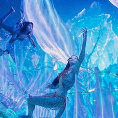 a woman dressed in blue is dancing under water