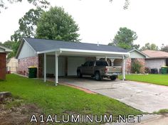 a truck is parked in the driveway of a house with a carport attached to it