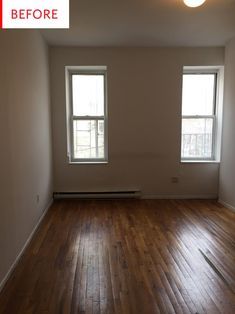 an empty room with hard wood floors and two windows