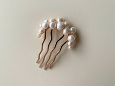 P1006 FRESHWATER PEARL HAIR PIECE Elegant hair comb made with love by Rositas! This stunning hair comb features an assortment of freshwater ivory pearls carefully hand wired onto a gold hair comb.  PRODUCT DETAILS Dimensions are approximately 2" (5 cm) (W) x 3" (7.5 cm) (H) PRODUCTION Each hair piece is handmade to order and therefore there may be slight variations from the listing photo.  VARIATIONS (SOLD SEPARATELY) This style is available in silver and gold Pearl Hairpiece, Pearl Hair Comb Wedding, Pearl Hair Piece, Pearl Comb, Pearl Hair Comb, Gold Hair Comb, Pearl Hair Combs, Wedding Hair Piece, Bride Headpiece