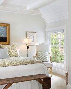 a bedroom with white walls and wooden furniture