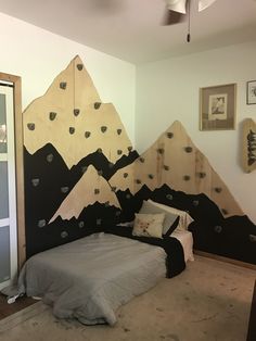 a bedroom with mountains painted on the wall