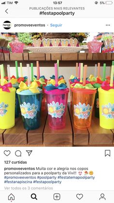 several plastic cups with straws in them sitting on a table next to other cupcakes