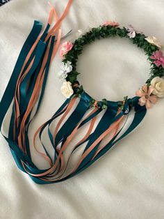 a flower crown and ribbon on a bed