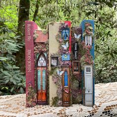 two books are sitting on top of a doily covered table with flowers and butterflies