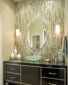 a bathroom with a sink, mirror and two lights on the side of the wall