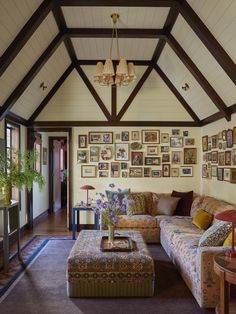 a living room filled with lots of furniture and pictures on the wall above it's coffee table