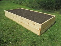 a wooden raised garden bed in the grass