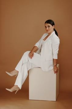 a woman sitting on top of a white box