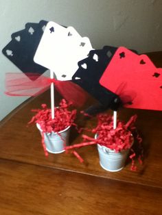 four cards are placed on top of each other in small buckets with sticks sticking out of them