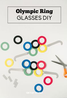 olympic ring glasses - diy with scissors and paper clips on top, in front of the olympics logo