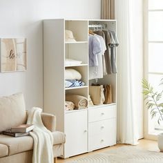 a living room filled with furniture and a white book shelf next to a window covered in curtains